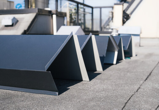 New roof metal flashing or metal coping before installation. Custom sheet metal fabrication to repair or install flat roof wall with modified bitumen. Large metal corners. Selective focus.