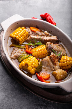 Chilean cuisine of Latin America. Traditional Chilean cazuela de cerdo. Pork soup with potatoes and corn, stew with corn and carrots on grey background vertical photo