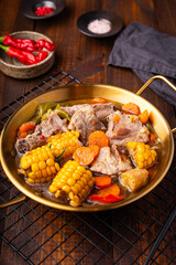 Chilean cuisine of Latin America. Traditional Chilean cazuela de cerdo. Pork soup with potatoes and corn, stew with corn and carrots on dark wooden background vertical photo
