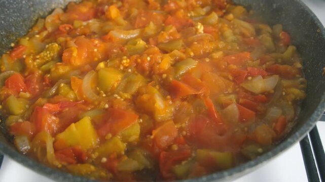 Vegetables stew cooking in frying pan on kitchen close up view. Culinary techniques, homemade preparing healthy meal vegetarian cook food dish, cuisine, seasoning garlic. Healthy vegan domestic food.