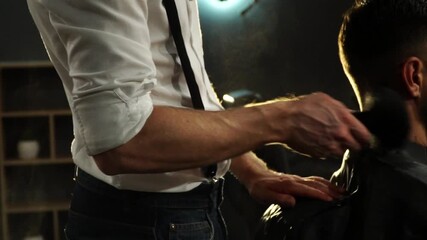 Barber skillfully using a brush to remove hair clippings from a client's neck, showcasing the meticulous grooming process in a stylish salon environment with soft lighting and modern decor