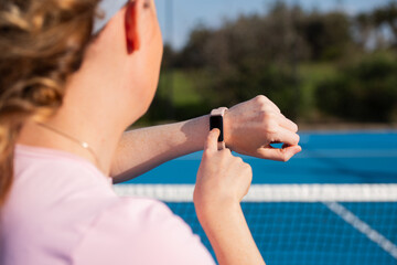 woman checking the data on her fitness tracker smartwatch
