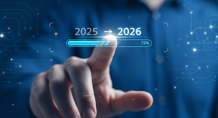 Fototapeta premium Person's finger pointing at a progress bar showing the transition from 2025 to 2026, indicating future planning.