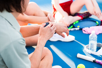 a man checks his watch during a post-tennis conversation