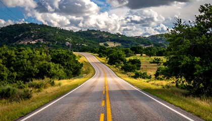 Naklejka premium Winding road through countryside under a partly cloudy sky
