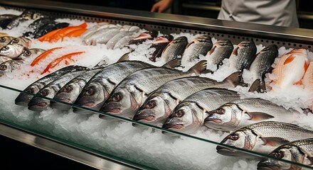 Fresh seafood displayed on ice in a market display case.  Various types of fish, including bass and salmon, are arranged neatly on a bed of ice.