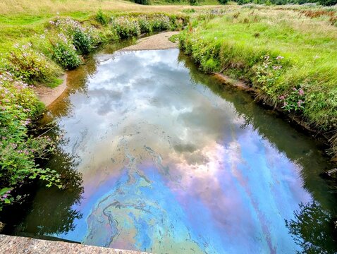 Oil pollution contaminating River Dean in Cheshire, England, UK.