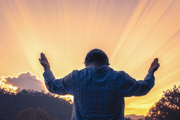 Human praying with hands raised to the sky