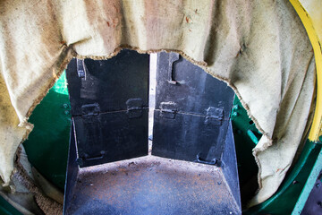 A coal storage room in an old steam locomotive. Close view of an old machine part showcasing a green and yellow design with open doors revealing interior details