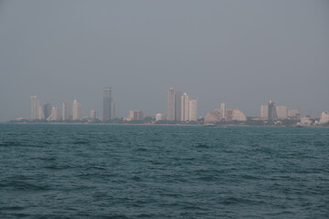 Fototapeta premium A stunning coastal city skyline at dusk with calm and serene waters reflecting the beauty of nature