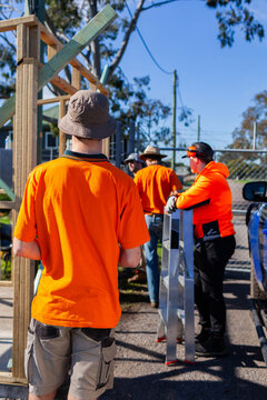 Group of trade apprentice workmen learning on the job while constructing ticket booth