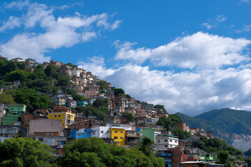 Colorful houses on a hillside with blue sky and clouds