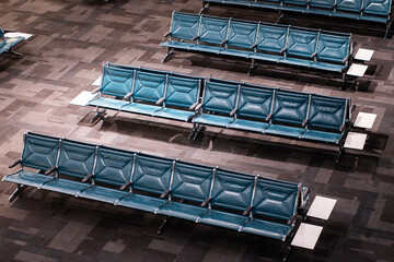 Modern Airport Waiting Area with Rows of Blue Seats, Spacious Terminal Lounge Featuring Contemporary Chair Arrangements