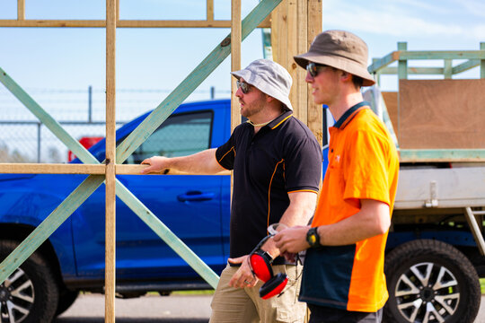 Trade instructor teaching students during hands on learning course building frame of ticket booth