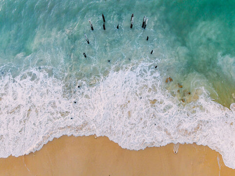 Aerial view of waves washing around derelict wooden pylons at Port Willunga in South Australia