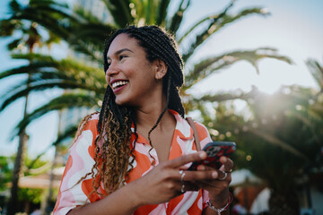 Smiling woman looking away while holding digital tablet, symbolizing optimism, innovation, and the...