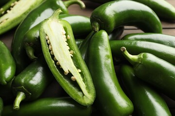 Fresh jalapeno peppers on table, closeup. Whole and cut