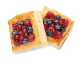 Tasty puff pastries with berries isolated on white, top view
