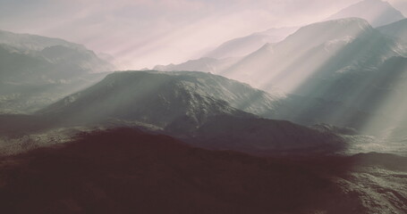 Sunlight streams through clouds over rugged mountains, creating a tranquil atmosphere. The scene captures the natural beauty and majesty of the landscape during twilight hours.
