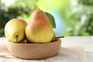 Fresh ripe pears in bowl on white table outdoors, closeup. Space for text