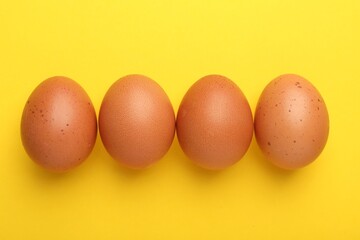 Raw chicken eggs on yellow background, flat lay