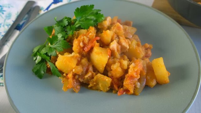 Served vegetables potatoes and chicken meat stew with parsley on plate on kitchen. Culinary techniques, homemade preparing healthy meal cook food, organic cuisine from fresh ingredients.
