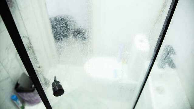 White marks and hard water stains on the transparent shower doors in the bathroom. Unsanitary and Hygiene Cleaning Solution, industry - Powered by Adobe