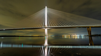 Queensferry Crossing bridge illuminating Firth of Forth at night