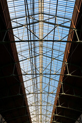 Glass roof of a historic industrial building in Portugal. Symmetrical architecture with riveted...