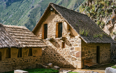 View of traditional stone buildings with thatched roofs at the Ollantaytambo Archaeological Site in the Sacred Valley of Peru