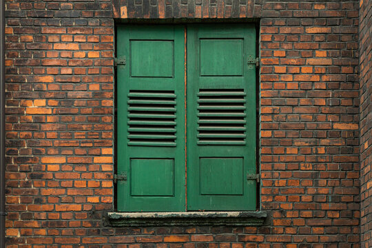 Fototapeta Zielona okiennica w kamienicy z cegły