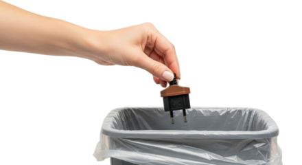 Isolated conceptual shot of obsolete electrical plug being discarded into garbage container