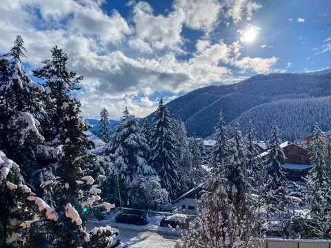 Clearing in the winter mountains on sunny day for outdoor activites and walks. Winter calm mountain landscape with rime and snow covered spruce trees. View on snowy mountains of Auron , France. 