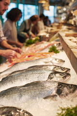 Fresh seafood selection at a bustling supermarket counter in a m