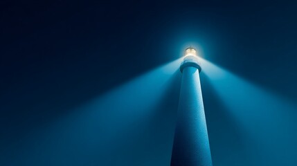 Tall, white lighthouse shining brightly in the dark night sky, guiding ships