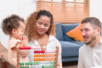 Happy family playing educational games with smiling children on living room table at home. Happy family playing with their kids on a weekend.