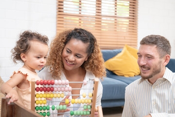 Happy family playing educational games with smiling children on living room table at home. Happy family playing with their kids on a weekend.