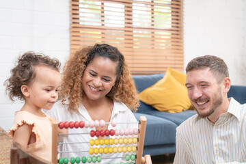 Happy family playing educational games with smiling children on living room table at home. Happy family playing with their kids on a weekend.