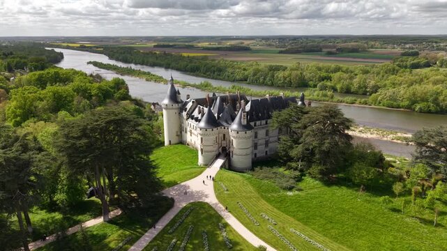 Aerial view of the majestic Chaumont castle, with its white stone facade contrasting against the lush green landscape and the flowing Loire river, Chaumont-sur-Loire, Centre-Val de Loire, France.