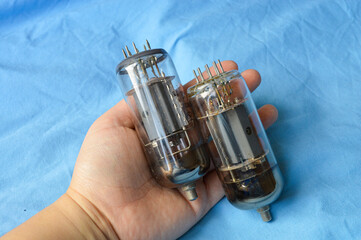 vintage vacuum tubes on blue background, retro electronic components used in radios and amplifiers,...