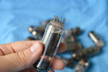 vintage vacuum tubes on blue background, retro electronic components used in radios and amplifiers,...