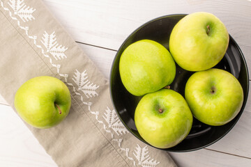 Green juicy apples on a wooden table, macro, top view.