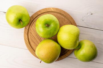 Green juicy apples on a wooden table, macro, top view.