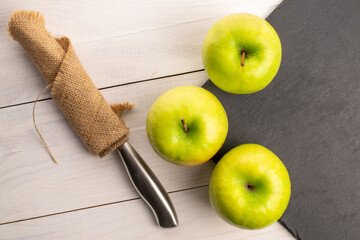 Green juicy apples on a wooden table, macro, top view.