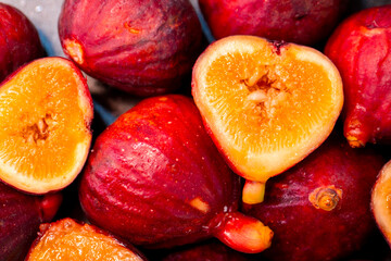 Figs close-up. Heap of figs, whole fruits and cut in half. Sweet exotic fruit for dessert, healthy food.