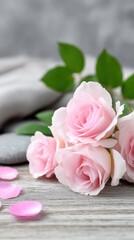 Fototapeta premium Soft pink roses arranged with smooth stones and green leaves create a serene and calm atmosphere perfect for relaxation and contemplation