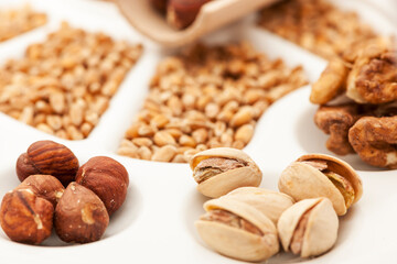 Pistachio nuts in a wooden bowl isolated on white background