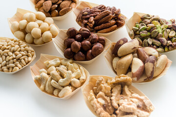 Pistachio nuts in a wooden bowl isolated on white background