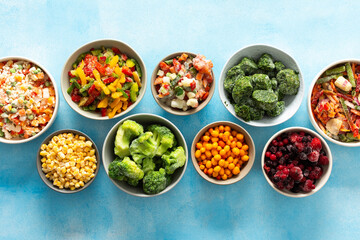 Fresh vegetables frozen in summer, neatly arranged in plates, ready for winter meals, showcasing vibrant colors and healthy options for future cooking, , vegetables in plates on a blue background