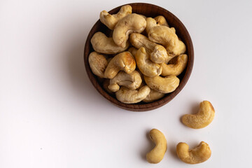 Raw peeled cashew nuts in a wooden bowl.